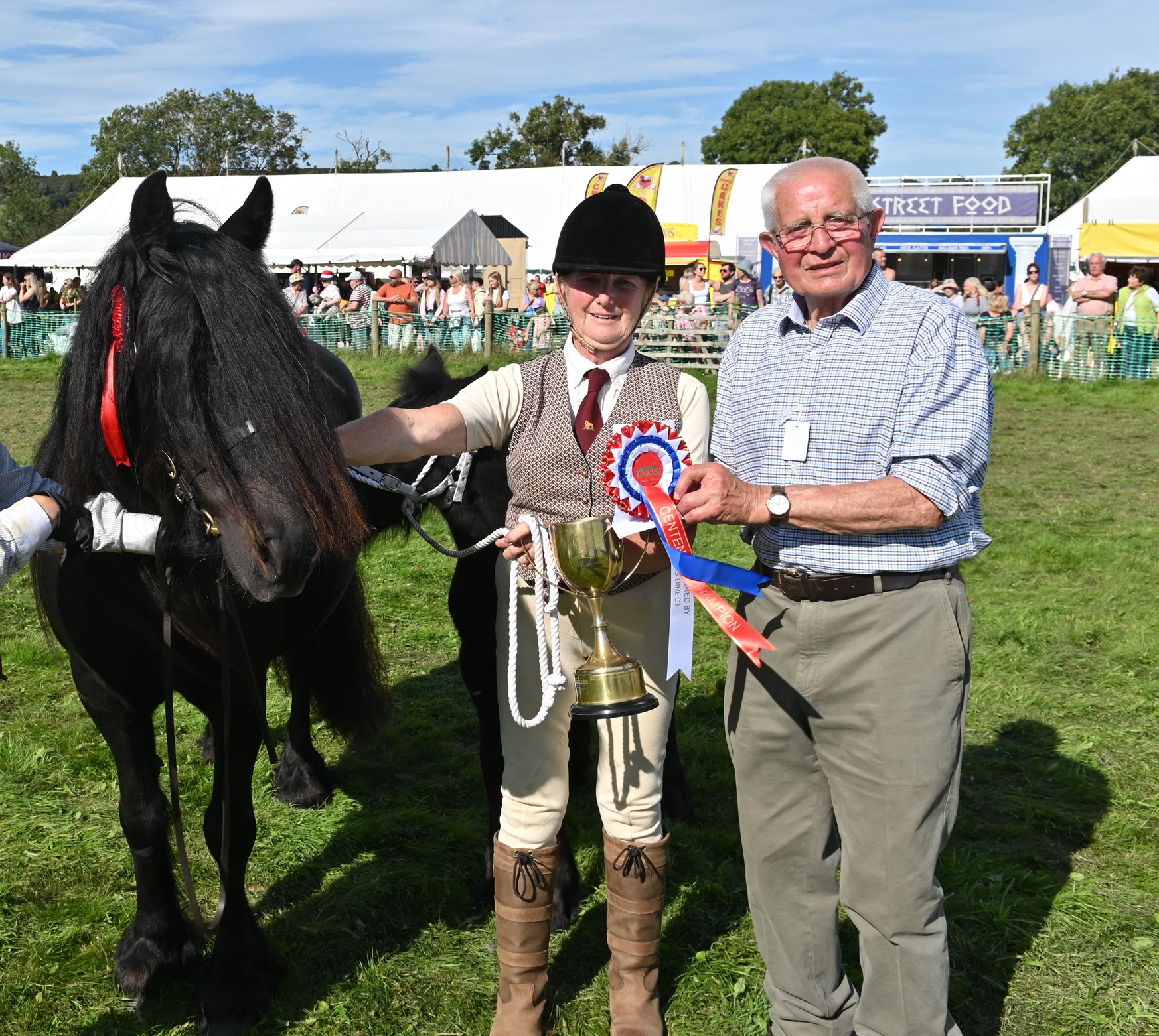 black mare, judge and handler with ribbons 